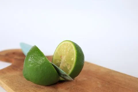 Lime on a cutting board split with a knife Stock Photos