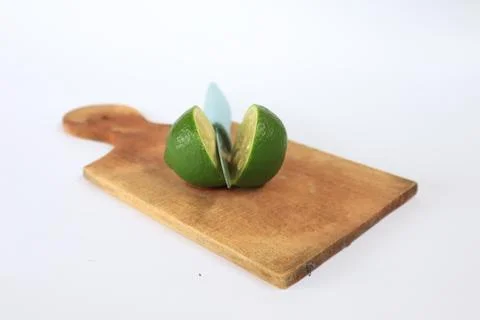 Lime on a cutting board split with a knife Stock Photos