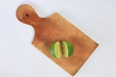 Lime on a cutting board split with a knife Stock Photos