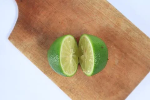 Lime on a cutting board split with a knife Stock Photos