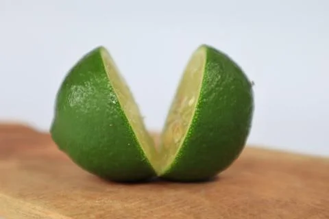 Lime on a cutting board split with a knife 스톡 사진