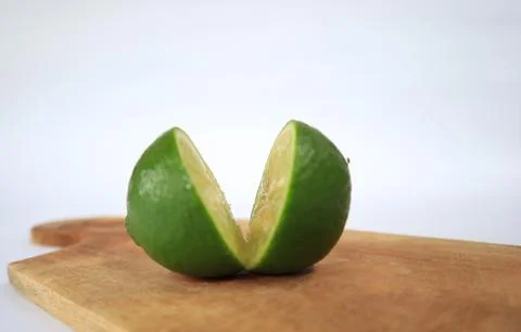 Lime on a cutting board split with a knife Stock Photos