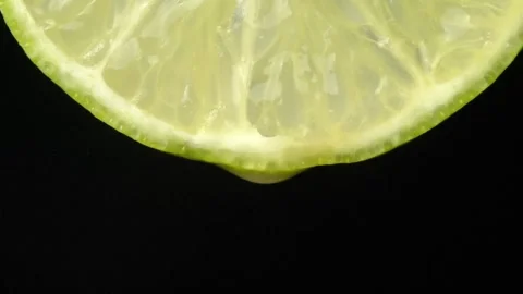 Lime with dripping clear juice on black background Stock Footage 248788980