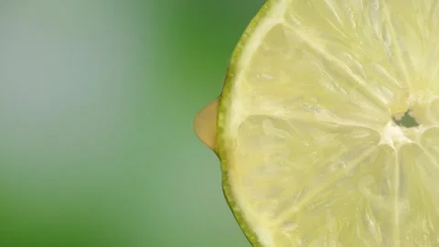 Lime with dripping clear juice on black background Vídeo Stock 251915507