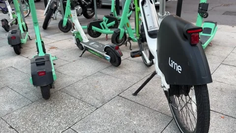 Lime e-bike and Bolt electric scooters parked Stock Footage 255720424
