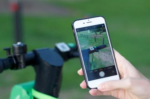 Lime e-scooter handlebar and mobile phone ready for scan Stock Photos