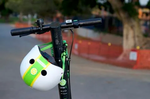 Lime E-scooter handlebars and helmet Stock Photos