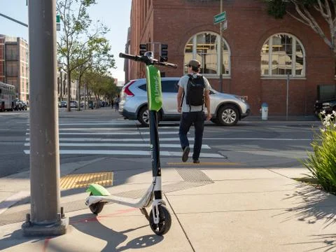 Lime electric scooter resting at an intersection in San Francisco, CA Stock Photos