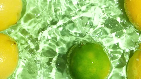 Lime falling into water with lemons, creating a splash in slow motion Stock Footage 346611007