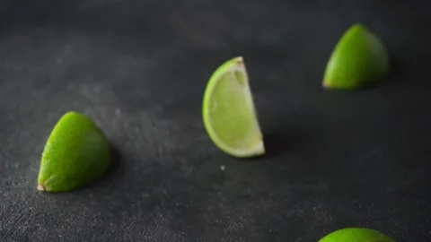 The lime falls on a black surface and shatters into pieces. Stock Footage 168409445