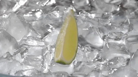Lime falls on ice cubes in water Video stock 77922544