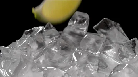 Lime falls on ice cubes in water Video stock 77925837