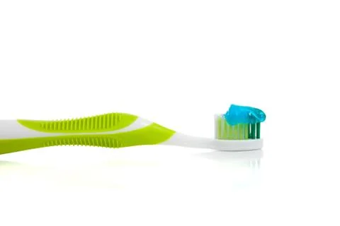 Lime green toothbrush and toothpaste on white Stock Photos
