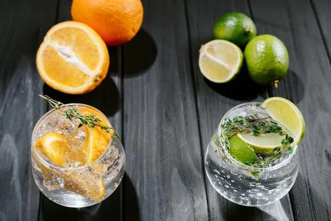 Lime lemonade with thyme, ginger and ice and orange. wooden dark background Stock Photos