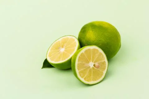 Lime with mint leaves isolated on light green background. Stock Photos