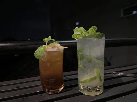 Lime mojito and lychee tea being served on a bar. Stock Photos