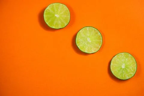 Lime on the orange background Stock Photos