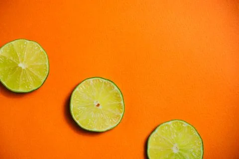 Lime on the orange background Stock Photos