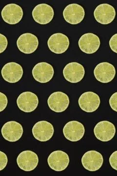 Lime pattern on black background. Minimal flat lay concept. Stock Photos