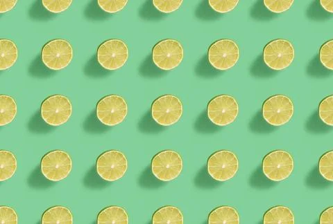 Lime pattern with hard shadow on a green background, top view. Stock Photos