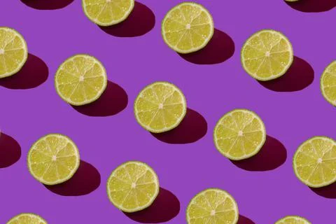 Lime pattern on a purple background. Pop art design, creative citruses. Yellow Foto stock
