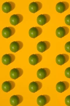 Lime pattern on yellow background. Minimal flat lay concept. Stock Photos