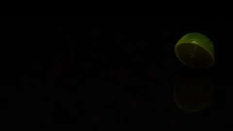 Lime rolls out on a black table Stock Footage