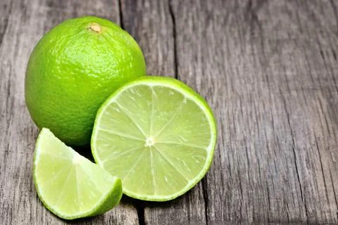 Lime on rustic wood board background Stock Photos
