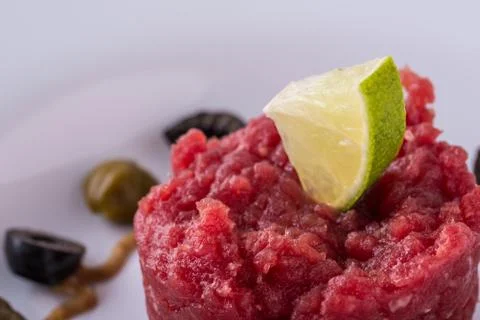 Lime on single portion of tartar steak Stock Photos