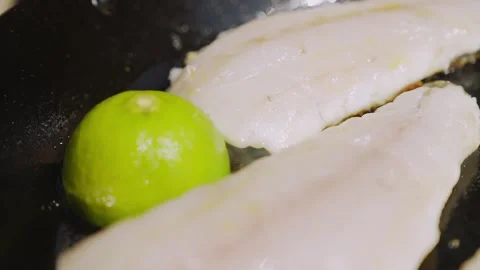 A lime sits on top of two fish fillets Stock Footage 298247657