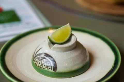 Lime slice and cut in to small pieces, places on a white ceramic plate and wi Stock Photos
