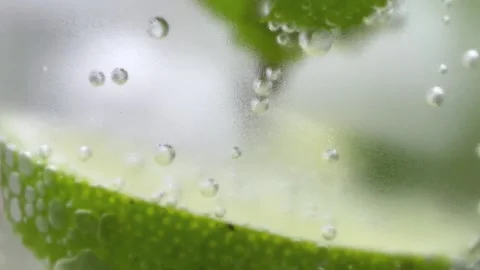 Lime slice and mint with air bubbles through a misted glass. Stockbeeldmateriaal 201168565