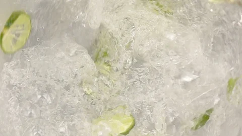 Lime slice and mint into water swirling slow motion Stock Footage 95222485