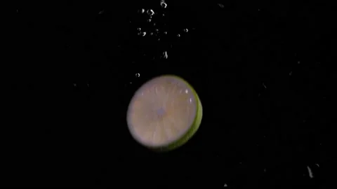 Lime Slice Falling into Water Super Slowmotion, Black Background, lots of Stock Footage 145809852