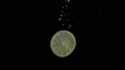 Lime Slice Falling into Water Super Slowmotion, Black Background, lots of Stock Footage 145809913