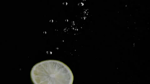 Lime Slice Falling into Water Super Slowmotion, Black Background, lots of Stock Footage 145809945