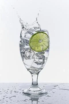 Lime slice makes a big splash in water. Stock Photos