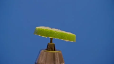 Lime slice spinning on blue screen 库存影片 220755807