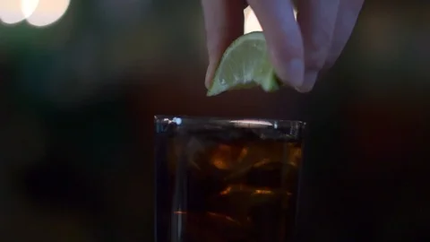 From the lime slice squeeze the juice into a glass Stock Footage 93970593