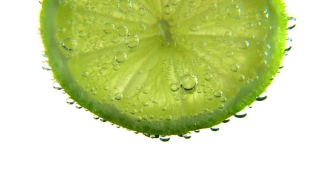 Lime slice suspended in carbonated liquid generating bubbles. Stock Footage 66260429