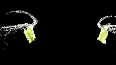 Lime slice with water droplets collide on black background super slow motion Stock Footage 116959596