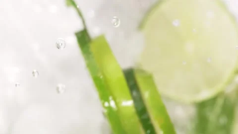 Lime slices and mint leaves flying up, mojito concept. Exploding water drop.. Stock Footage 310545574