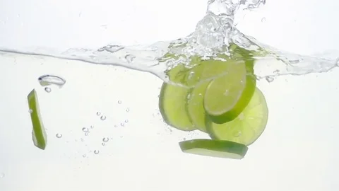 Lime Slices are Falling Through Water. Stock Footage 72450017
