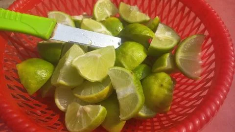 Lime slices in a basket with a knife, close-up Stock Photos