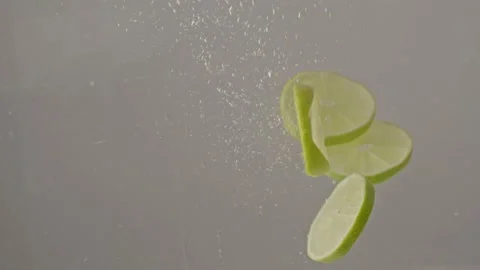 Lime slices dropping into water in slow motion 库存影片 220755802