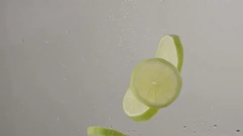 Lime slices dropping into water in slow motion Stock Footage 220755804