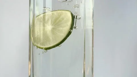 Lime slices fall falling into a glass of water Stock-Footage 134287209