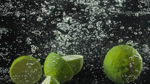 Lime slices fall into the water. Black background . Macro mode. Slow mo Stock Footage 144334562