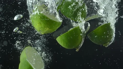 Lime slices fall into the water. Black background . Macro mode. Slow mo Stock Footage 144334582