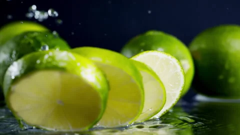 Lime slices fall into the water on yellow background Super slow-mo 1000 fps Stock Footage 276732453